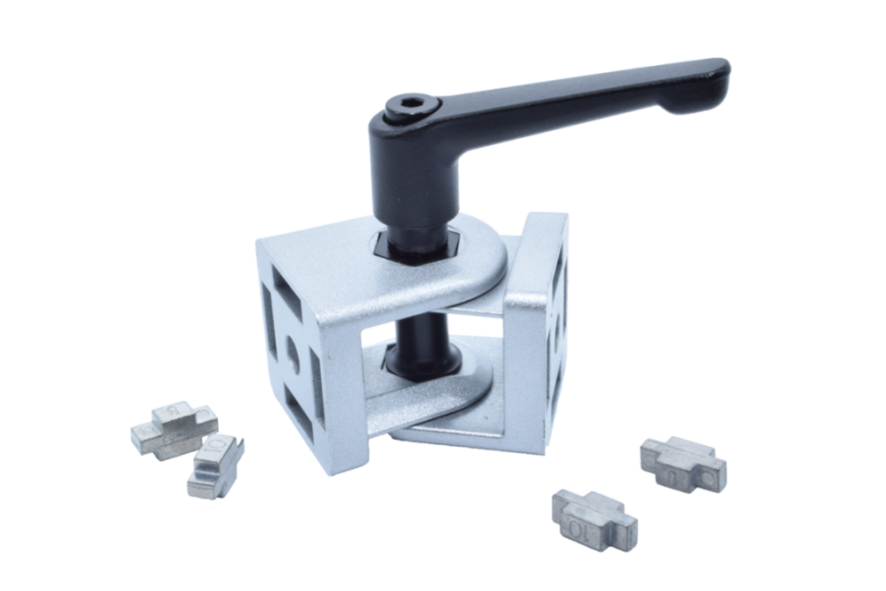 Gelenkverbinder 40 mm aus Zinkdruckguss mit schwarzem Klemmhebel, davor vier Zentrierstücke aus Metall