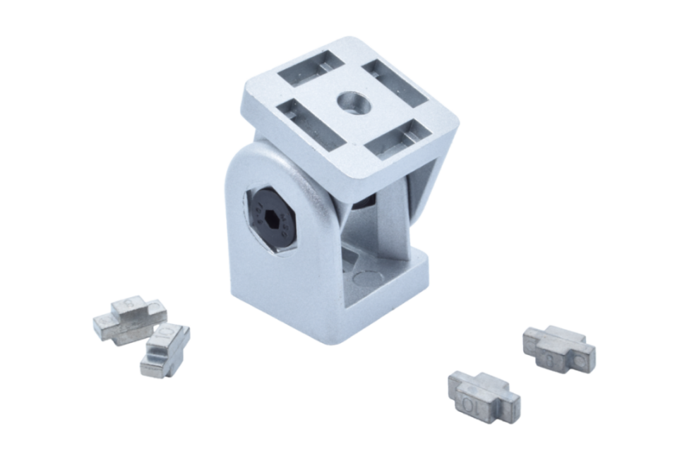 Gelenkverbinder 40 mm ohne Klemmhebel aus Zinkdruckguss, davor vier Zentrierstücke aus Metall